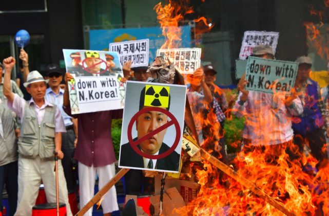 South Korean conservative activists set fire to a portrait of North Korean leader Kim Jong-Un during a protest denouncing North Korea's nuclear test in Seoul on September 10, 2016. South Korean newspapers sounded the alarm on September 10 over what one termed the "nuclear maniac" Kim Jong-Un, saying the North Korean leader's fifth and biggest nuclear test is a game-changer demanding a tougher response. / AFP PHOTO / JUNG YEON-JE